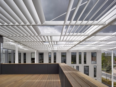 Sjednocujícím prvkem celého areálu je subtilní kovová stínicí konstrukce, která je reminiscencí velmi krátkých laserových pulsů