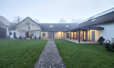 Vstup do areálu tvoří společně s chodbou hlavní osu skrz střední křídlo usedlosti a komunitní místnosti do zahrady. Dostavěné prostory byly navrženy jako dřevostavby, mají shodné konstrukční a materiálové řešení, detaily a návaznosti jsou jednoduché.