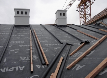 Skladba střechy třída těsnosti 1: dřevěné bednění; difuzně otevřená DHV (pojistná hydroizolace) DELTA-ALPINA, umožňující homogenní spoj; kontralatě jsou kryty přířezovými pásy DELTA-ALPINA. Tepelný izolant se následně ze spodní strany doplní bezprostředně k bednění bez jakékoliv větrané mezery.