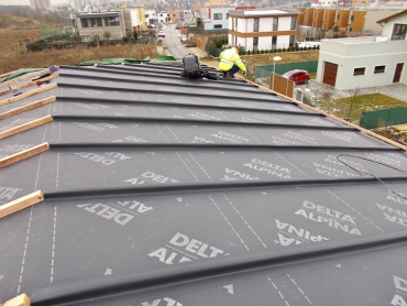 Skladba střechy třída těsnosti 1: dřevěné bednění; difuzně otevřená DHV (pojistná hydroizolace) DELTA-ALPINA, umožňující homogenní spoj; kontralatě jsou kryty přířezovými pásy DELTA-ALPINA. Tepelný izolant se následně ze spodní strany doplní bezprostředně k bednění bez jakékoliv větrané mezery.