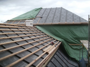 Skladba střechy třída těsnosti 1: dřevěné bednění; difuzně otevřená DHV (pojistná hydroizolace) DELTA-ALPINA, umožňující homogenní spoj; kontralatě jsou kryty přířezovými pásy DELTA-ALPINA. Tepelný izolant se následně ze spodní strany doplní bezprostředně k bednění bez jakékoliv větrané mezery.