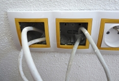 Obr. 14–16: Největší netěsnosti zjištěné při kontrolním testu vzduchotěsnosti obálky budovy – nevhodně zpracovaný detail parapetu u rohového okna, netěsnost kolem svazku kabelů a proudění vzduchu neutěsněnými chráničkami kabelů.