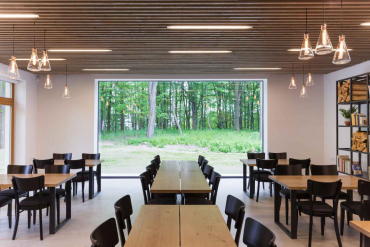 Velkoformátové zasklení v restauraci otevírá prostor do přírody. Lehký dřevěný podhled ukrývá instalační trasy kanalizace, topení, elektro a dalších médií.