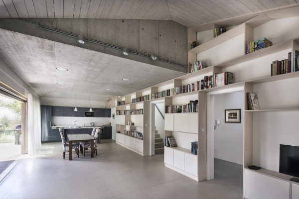 Klidné a přirozené plochy betonu v kombinaci se světle mořeným dřevem odpovídají představám majitelů domu o současném, prosvětleném a prostorově velkorysém interiéru