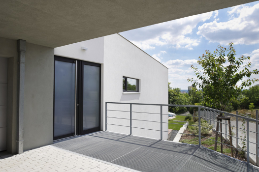 Vstupní část domu se nachází v nejvyšším místě parcely v úrovni ulice. Vybudována byla z betonových tvarovek ztraceného bednění.