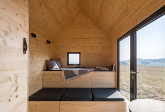 Pomocí polohování vestavěného nábytku se může přizpůsobit dispozice různým funkcím, na vyvýšeném lůžku v přízemí s dvěma řadami výsuvných šuplíků se po rozložení vyspí dva lidé (horní řada zásuvek jsou úložné prostory) a nahoře v patře nad plně vybavenou kuchyňkou je ještě manželská postel