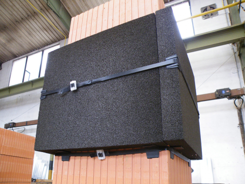 Všechny čtyři slepené desky okolo komína stáhneme dodanou stahovací páskou. Před konečným stažením na hrany desek umístíme další plastové rohy, aby desky chránily před poškozením.