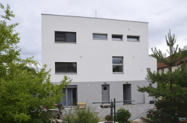 Pohled od severozápadu, kde je v suterénu malý byt s balkonovými dveřmi. Kromě toho tu jsou ještě vstupní dveře a dveře do místnosti TZB.