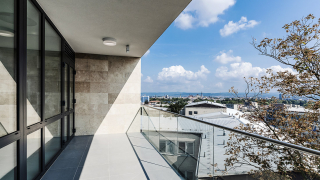 Fasáda je čistě bílá, na některých místech obložená travertinem