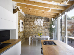 Interiéry přístavby – z jedné strany je vymezují parkány, z druhé dělicí zeď se sousedy. Kamenné zdi autoři mohli ponechat i proto, že místnost je v podstatě průchozí, tedy provětrávaná.