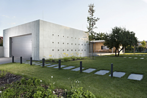 Na východní straně pavilonu je dvojgaráž, na západní straně technické zázemí se skladem a letní kuchyní, která navazuje na centrální část s terasou a bazénem