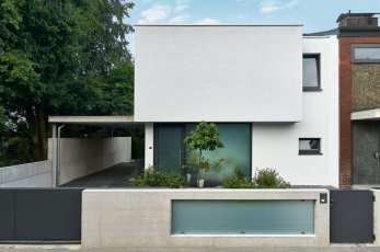 Podlaha horního patra na jedné straně vystupuje z objektu a tvoří zastřešení parkovacího místa (vpravo na fotografii: okenní systémy Schüco AWS 75.SI)