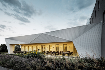 Restaurace Mimama s netradiční plošně prolamovanou fasádou obloženou prvky PREFA Siding