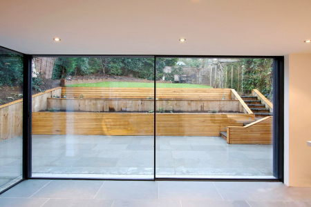 Obr. 5: Typické řešení celoskleněných odsuvných stěn, kdy posuvná část odjede do zákrytu za fixní část – polovina stěny je pak otevřená (zdroj: www.minimal-windows.com)