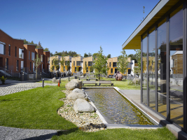 Mezi domy vzniklo náměstí s komponovanou zelení, sochařskou výbavou, vodní plochou a lavičkami. Součástí parku je také prosklená klubovna.