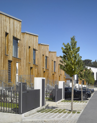 Fasáda části budov kombinuje omítku s obkladem z červeného cedru