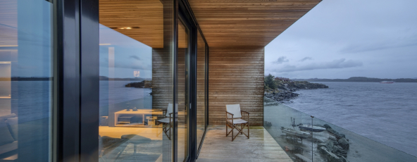 Rodinný pokoj o ploše 91 m² v horním patře s panoramatickým výhledem, umocněným fasádou tvořenou celostěnnými okny, která zasahuje za roh (fasádní systém Schüco FWS 50.HI v kombinaci s posuvným systémem se zdvihem Schüco ASS 70.HI), foto Sindre Ellingsen 