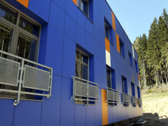 Příklad využití kompaktních desek pro fasádní obklad. Na rozdíl od cementovláknitých desek nebo skla jsou stálobarevné a nejsou tak křehké.