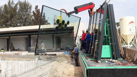 Jeřáb osazující prefabrikované panely o rozměrech 4x3 m z posuvného systému Schüco ASS 77 PD.NI