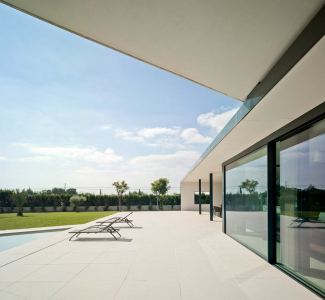 Venku i uvnitř je dlažba ze světlého přírodního kamene, která vizuálně propojuje a sjednocuje venkovní a vnitřní prostory