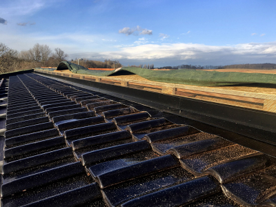 Nezateplený prostor vazníkové konstrukce je spolehlivě odvětrán – viz větrací otvory u pultu vyvedené nad úroveň krytiny. Tepelný izolant bude uložen ve vodorovné poloze na spodní pásnici vazníku. Proto je větrání nezbytné.