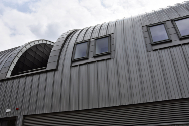 V kovem obloženém tunelu jsou jen občas v patře prolomena okna a mezi nimi několik atrií