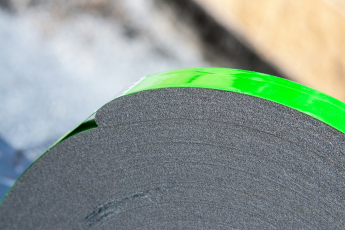 Integrovaný stahovavací pás pro udržení kotouče pásky ve stlačeném stavu