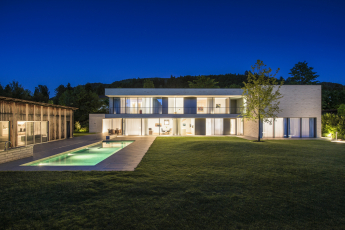 Zadní fasáda podlouhlé stavby se v obou výškových úrovních otevírá směrem do zahrady díky posuvným systémům 