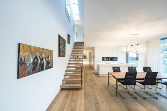 Rozdělení a uspořádání obou podlaží je dokonale přizpůsobeno svažitému pozemku nemovitosti. Samonosné schodiště vede ze vstupního prostoru (v přízemí, na straně orientované do ulice) dolů do hlavních obytných prostor na úrovni zahrady