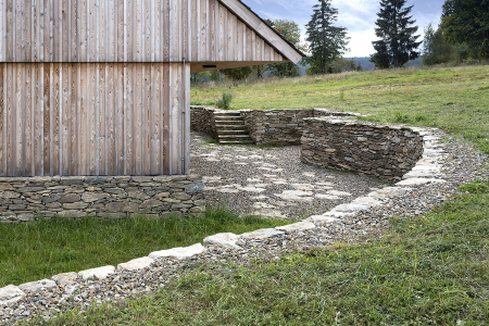 Pata domu je v exponovaných částech ochráněna vůči povětrnosti masivním, na sucho skládaným kamenným soklem