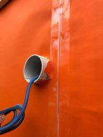 Ochrana zateplené fasády s obkladem s otevřenými spárami. Fotografie ze stavby v rozpracovaném stavu - barva jantarově oranžová (zdroj: Dörken)