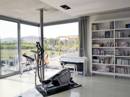 Pohledový beton je výrazným prvkem i v interiéru – například v obývací části, kuchyni a jídelně