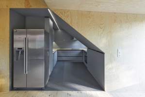 Pohled do kuchyně: klienti už v podkroví mnohokrát zažili velmi horké letní měsíce a jejich snem byla lednice, z níž padají kostky ledu a teče dobře vychlazená voda. Stojí tedy na „pomezí“ mezi obývacím pokojem a kuchyní