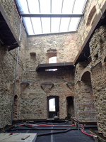 Obr. 5: Stav zdiva po konzervaci, zbytky kleneb chráněny olověným plechem. Zastřešení vloženo do novodobé části koruny zdi, distance mezi stěnami umožňuje vertikální proudění vzduchu. Odvodnění střechy pomocí ocelových trub, duben 2020.