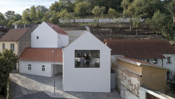 Místo má genius loci ulice v někdejší vesnici za Prahou. Původní domek zůstal zachován, architekti dále pracovali s podobnými hmotami. Rodinný dům tedy tvoří tři objekty, novostavby jsou umístěny směrem do svahu
