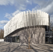 Zavěšená fasáda z hliníkových lamel tvoří kontrast k historické fasádě původního objektu