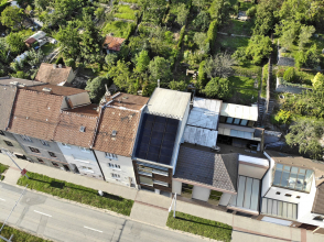 Situace: směrem do ulice domy vytvářejí souvislou uliční zástavbu, u zadních fasád na ně navazují poměrně velkorysé zahrady. Na střeše domu byly osazeny fotovoltaické panely.