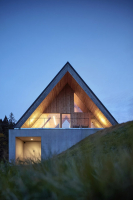 Prosklené štítové stěny propojují interiéry s okolní přírodou, zanoření podlahy zároveň poskytuje soukromí