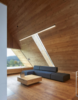 Modřín a sklo v celém interiéru, který tvoří volně plynoucí prostor s výhledy do hor