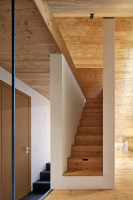 Modřín a sklo v celém interiéru, který tvoří volně plynoucí prostor s výhledy do hor