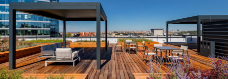 Revitalizovaná střešní terasa s posezením pod pergolou a zvýšenými záhony