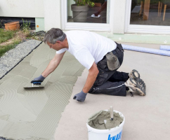 Na podklad naneseme tenkou vrstvu lepidla Flexkleber Schnell, pro každý pás zvlášť