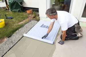 Do lepidla přitiskneme hydroizolační tkaninu Hydroflex