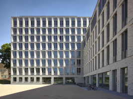 Fasádu tvoří částečně zkosené meziokenní pilíře, oddělené průběžnými římsami. Celý dům je obložený keramic kými taženými pásky, rámy oken jsou skryté za konstrukcí fasády. Okna mají užší otevíravou a širší fixní část