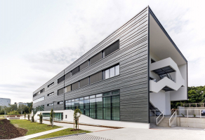 Obklad fasády z titanzinku je horizontálně členěný zvýrazněním úhlových drážek a opticky potlačených vertikálních spár. Na východní fasádě je výtvarně pojaté únikové schodiště.