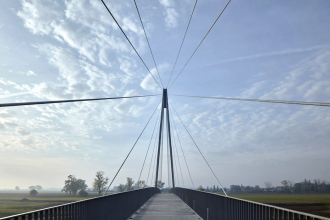 Závěsy tvoří 17 párů ocelových lan. V každém druhém segmentu jsou do podélných nosníků zabetonovány ocelové prvky pro připojení závěsu. Vzdálenost závěsů na mostovce je tedy 8 m. Únosnost uložení plechu do prvku z UHPC se testovala na vzorku, jenž tvarově odpovídal podélnému žebru segmentu, do kterého byl zabetonován kotevní plech skutečných rozměrů. Výsledky prokázaly více než dostatečnou únosnost zakotvení ocelového prvku do UHPC.