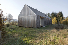 Vlnitý akrylát na štítových stěnách vytváří kontrast k dřevěnému domu