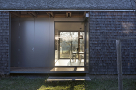 Obvodový plášť kolem ochozu tvoří dřevěná konstrukce s posuvnými panely ze štípaného šindele. Panely je možné fixovat v uzavřené poloze a dům tak zabezpečit. Sedlová střecha má krytinu rovněž ze štípaného šindele, její sklon 45° navazuje bez okapových hran na obvodový plášť. Konstrukci panelů tvoří ocelové rámy ze svařených pásovin, do kterých je vložena OSB deska. Šindele se kladly v řadách na OSB desky.