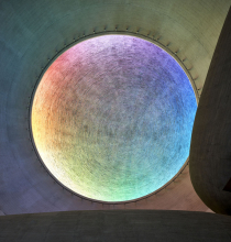 Asymetrickou kopuli vykresluje odražené světlo, otisk bednění tak působí jako otisk Božího prstu