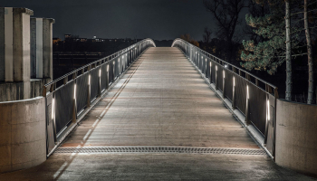 Svítidla jsou integrovaná do sloupků zábradlí po obou stranách lávky, mírně odsazených k okraji, aby je při průchodu zakryla konstrukce zábradlí a neoslňovala chodce